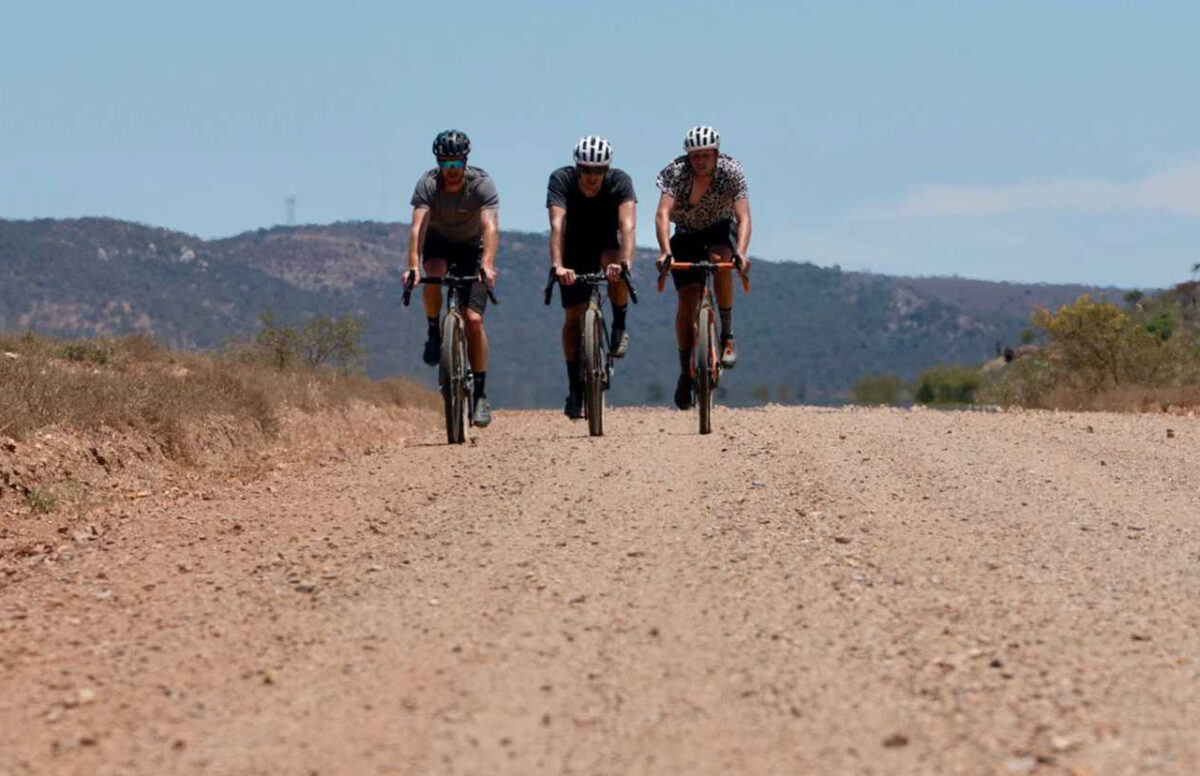 chasing-the-sun-gravel-bike-bike-market-1280x828-1 three gravel cyclists on a dirt road